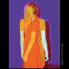 Book cover: Mom Camp by Veronique Darwin. A distorted photo of a woman in an orange dress is set in the middle of a purple rectangle.